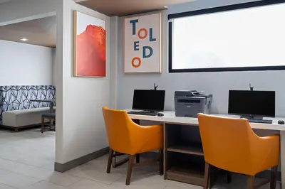 an office with a desk with two computers and orange chairs at Holiday Inn Express Toledo North by IHG in Toledo