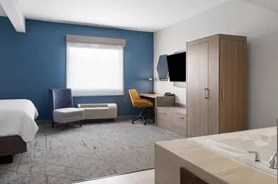 a bedroom with a bed and a desk with a television at Holiday Inn Express Toledo North by IHG in Toledo