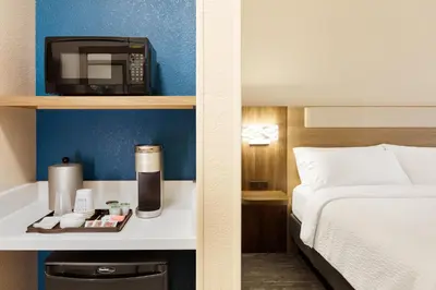 a hotel room with a bed and a microwave at Holiday Inn Express Toledo North by IHG in Toledo