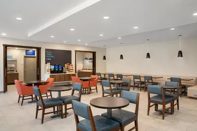 a restaurant with tables and chairs and a bar at Holiday Inn Express Richmond by IHG in Richmond