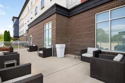 a patio with couches and chairs next to a brick building at Holiday Inn Express Richmond by IHG in Richmond