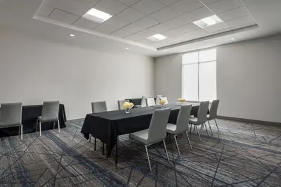 a conference room with a black table and chairs at Holiday Inn Express Richmond by IHG in Richmond