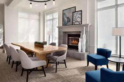 a dining room with a table and chairs and a fireplace at Hilton Garden Inn Fort Wayne in Fort Wayne