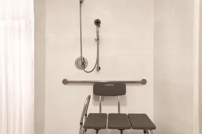 a chair in a bathroom with a shower at Hilton Garden Inn Fort Wayne in Fort Wayne