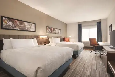 a hotel room with two beds and a desk at Hilton Garden Inn Fort Wayne in Fort Wayne