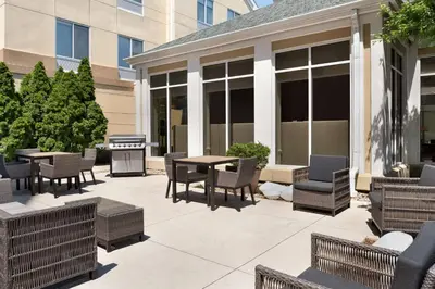 a patio with chairs and tables and a grill at Hilton Garden Inn Fort Wayne in Fort Wayne