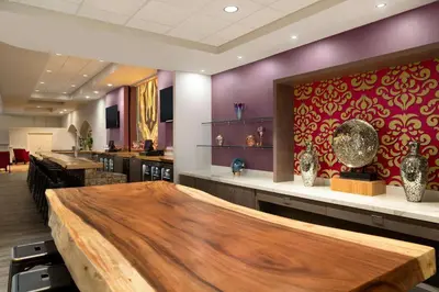 a restaurant with a large wooden table in a room at Hilton Fort Wayne at the Grand Wayne Convention Center in Fort Wayne