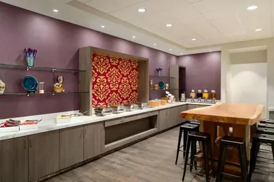 a restaurant with purple walls and a table and chairs at Hilton Fort Wayne at the Grand Wayne Convention Center in Fort Wayne