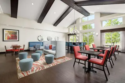 a dining room with tables and chairs and windows at Hampton Inn & Suites Fort Wayne-North in Fort Wayne