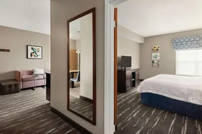 a hotel room with a bed and a mirror at Hampton Inn & Suites Fort Wayne-North in Fort Wayne