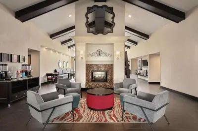 a living room with chairs and a fireplace at Hampton Inn & Suites Fort Wayne-North in Fort Wayne