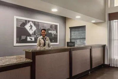 a boy standing at a counter in a hotel lobby at Hampton Inn & Suites Fort Wayne-North in Fort Wayne