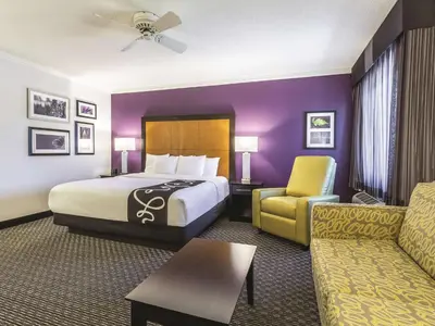 a hotel room with a bed and a couch at La Quinta by Wyndham Cleveland - Airport North in Cleveland