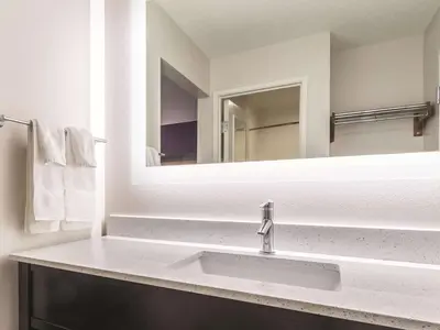 a bathroom with a sink and a mirror at La Quinta by Wyndham Cleveland - Airport North in Cleveland