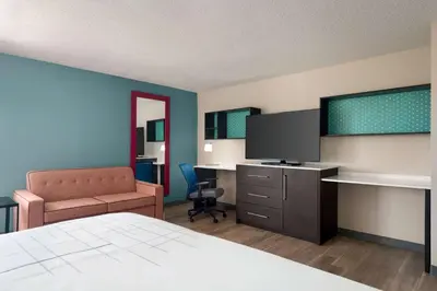 a hotel room with a bed and a tv and a chair at La Quinta Inn by Wyndham Columbus Dublin in Dublin