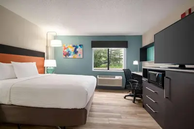 a hotel room with a bed and a flat screen tv at La Quinta Inn by Wyndham Columbus Dublin in Dublin
