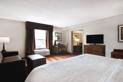 a hotel room with a bed and a flat screen tv at Hampton Inn Fort Wayne-Southwest in Fort Wayne