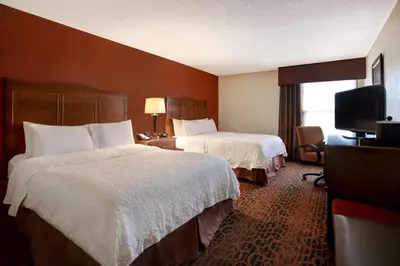 a hotel room with two beds and a flat screen tv at Hampton Inn Fort Wayne-Southwest in Fort Wayne