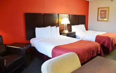 a hotel room with two beds and a chair at Country Hearth Inn & Suites - Kenton in Kenton