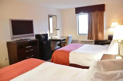 a hotel room with two beds and a flat screen tv at Country Hearth Inn & Suites - Kenton in Kenton
