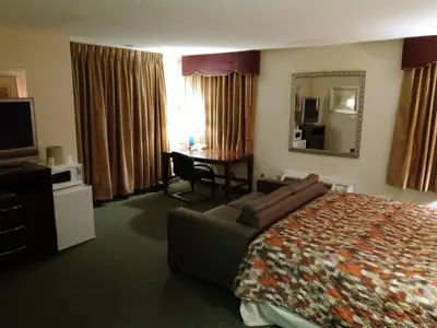 a hotel room with a bed and a couch and a desk at Country Hearth Inn & Suites - Kenton in Kenton