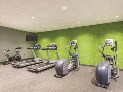 a gym with several tread machines in a room at La Quinta by Wyndham Cincinnati Sharonville in Sharonville