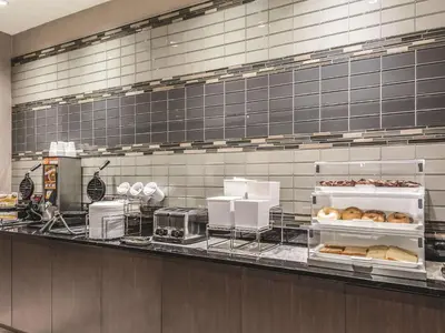 a bakery counter with a bunch of donuts on it at La Quinta by Wyndham Cincinnati Sharonville in Sharonville