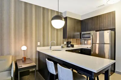 a kitchen with a refrigerator and a table with chairs at Residence Inn by Marriott Cleveland Airport/Middleburg Heights in Middleburg Heights