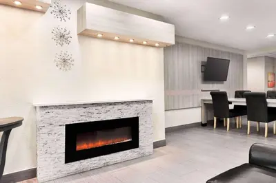 a living room with a fireplace and a table at Microtel Inn & Suites by Wyndham Florence/Cincinnati Airpo in Florence