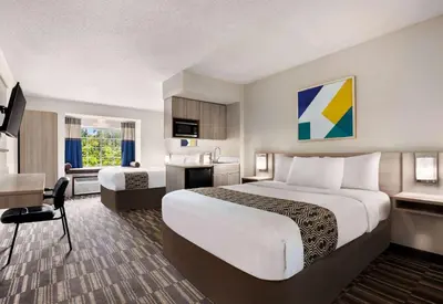 a hotel room with a large bed and a desk at Microtel Inn & Suites by Wyndham Florence/Cincinnati Airpo in Florence