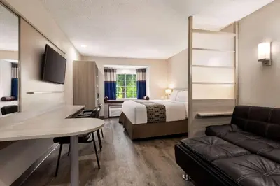a hotel room with a bed and a couch at Microtel Inn & Suites by Wyndham Florence/Cincinnati Airpo in Florence