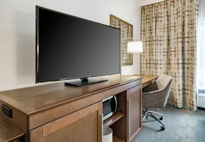 a large flat screen tv on a desk in a hotel room at Hampton Inn & Suites Newport/Cincinnati, KY in Newport
