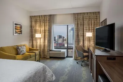 a hotel room with a bed and a flat screen tv at Hampton Inn & Suites Newport/Cincinnati, KY in Newport