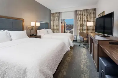 a hotel room with two beds and a flat screen tv at Hampton Inn & Suites Newport/Cincinnati, KY in Newport