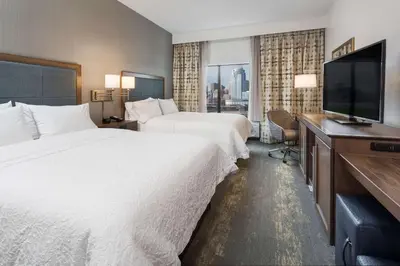 a hotel room with two beds and a flat screen tv at Hampton Inn & Suites Newport/Cincinnati, KY in Newport
