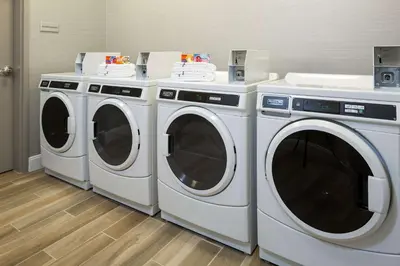 three washing machines are sitting in a laundry room at Hampton Inn & Suites Newport/Cincinnati, KY in Newport