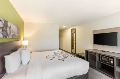 a hotel room with a bed and a flat screen tv at Sleep Inn Logan Ohio-Hocking Hills in Logan