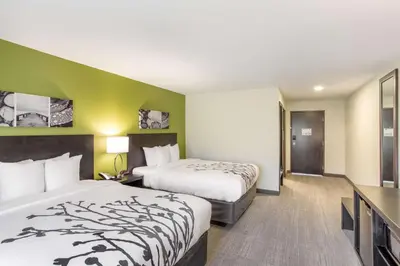 a hotel room with two beds and green walls at Sleep Inn Logan Ohio-Hocking Hills in Logan