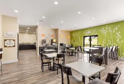 a restaurant with tables and chairs and a kitchen at Sleep Inn Logan Ohio-Hocking Hills in Logan