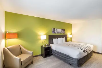 a hotel room with a bed and a chair at Sleep Inn Logan Ohio-Hocking Hills in Logan