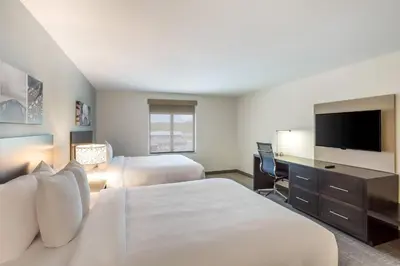 a hotel room with two beds and a flat screen tv at MainStay Suites Logan Ohio-Hocking Hills in Logan