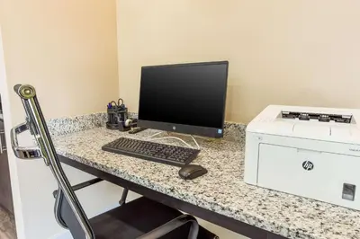 a desk with a computer monitor and a printer at MainStay Suites Logan Ohio-Hocking Hills in Logan