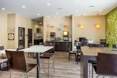 a restaurant with tables and chairs and a cafeteria at MainStay Suites Logan Ohio-Hocking Hills in Logan