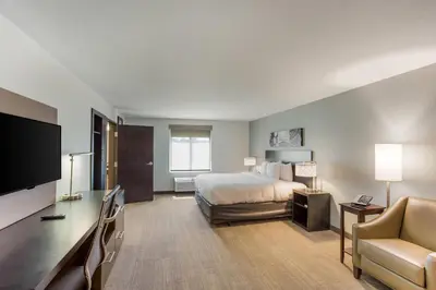 a large hotel room with a bed and a desk at MainStay Suites Logan Ohio-Hocking Hills in Logan