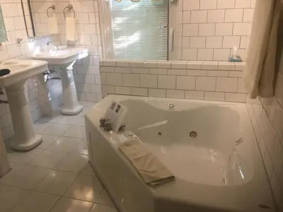 a white bathroom with a tub and two sinks at Bayberry House Bed and Breakfast in Steubenville