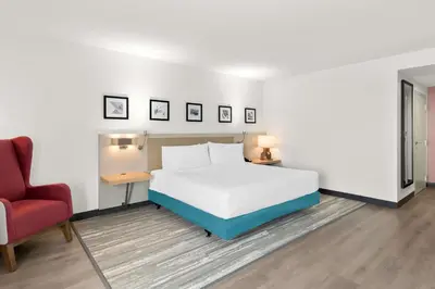 a bedroom with a bed and a red chair at Hilton Garden Inn Lexington Georgetown in Georgetown