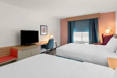 a hotel room with two beds and a desk and a tv at Hilton Garden Inn Lexington Georgetown in Georgetown
