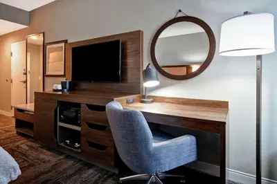 a room with a desk with a television and a mirror at Hampton Inn Lexington I-75 in Lexington