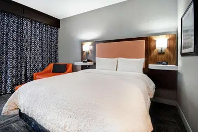 a hotel room with a large bed and a chair at Hampton Inn Lexington I-75 in Lexington