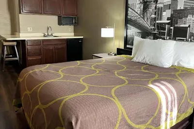 a hotel room with a bed and a kitchen at Super 8 by Wyndham Harrison OH in Harrison